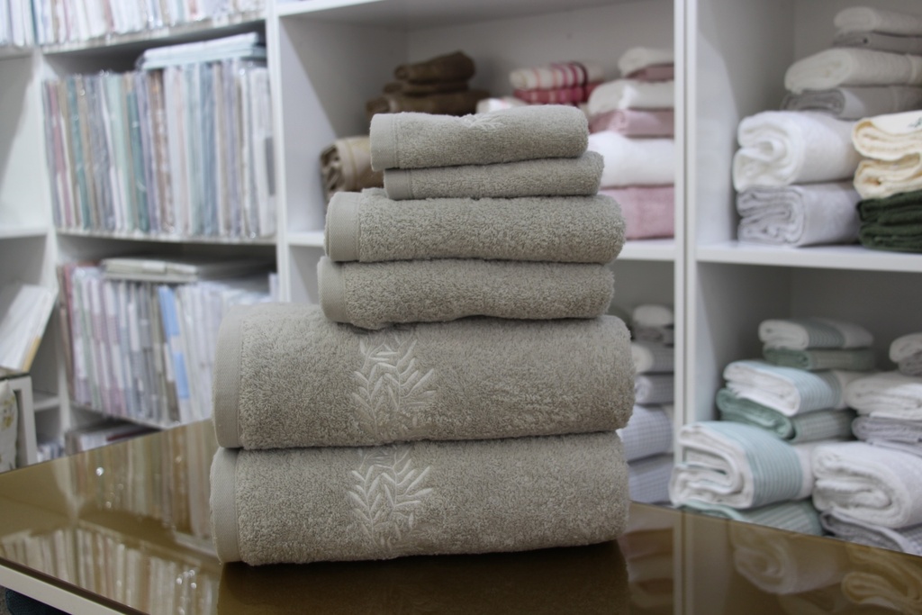 Conjunto de toalhas beges com bordado de folhas