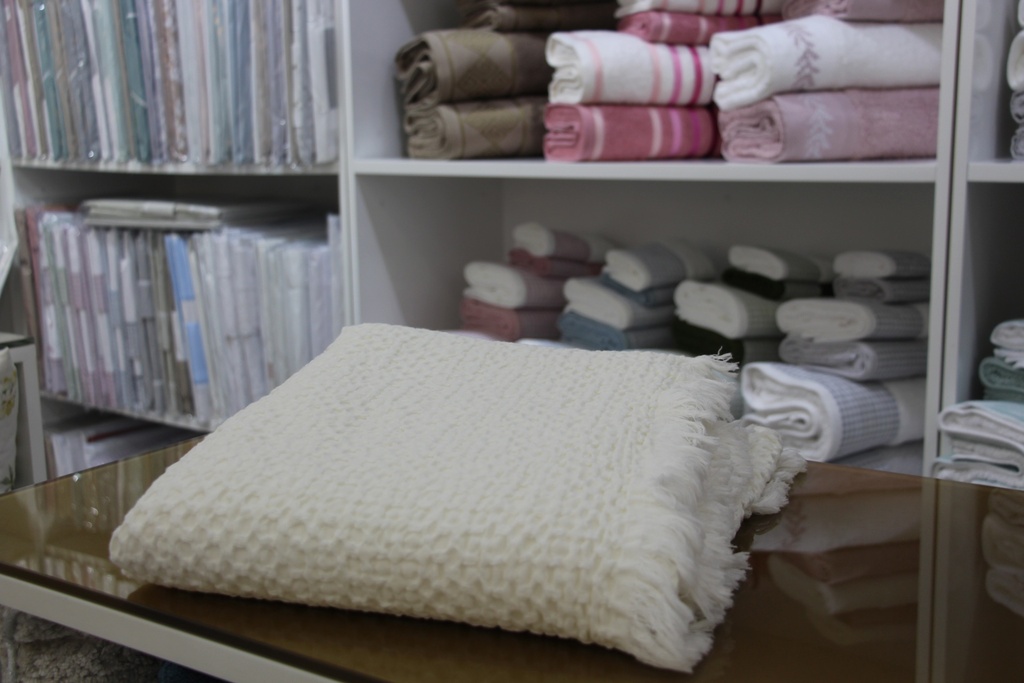 Manta decorativa bege com padrão de favo de mel