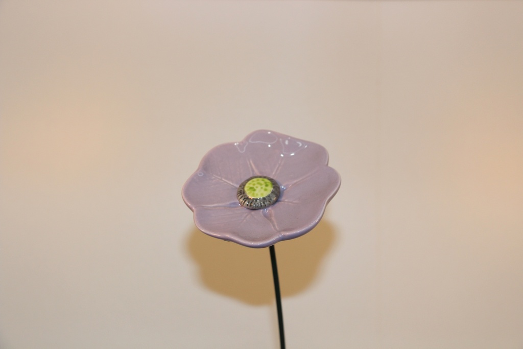 Flor decorativa em cerâmica lilás com haste metálica