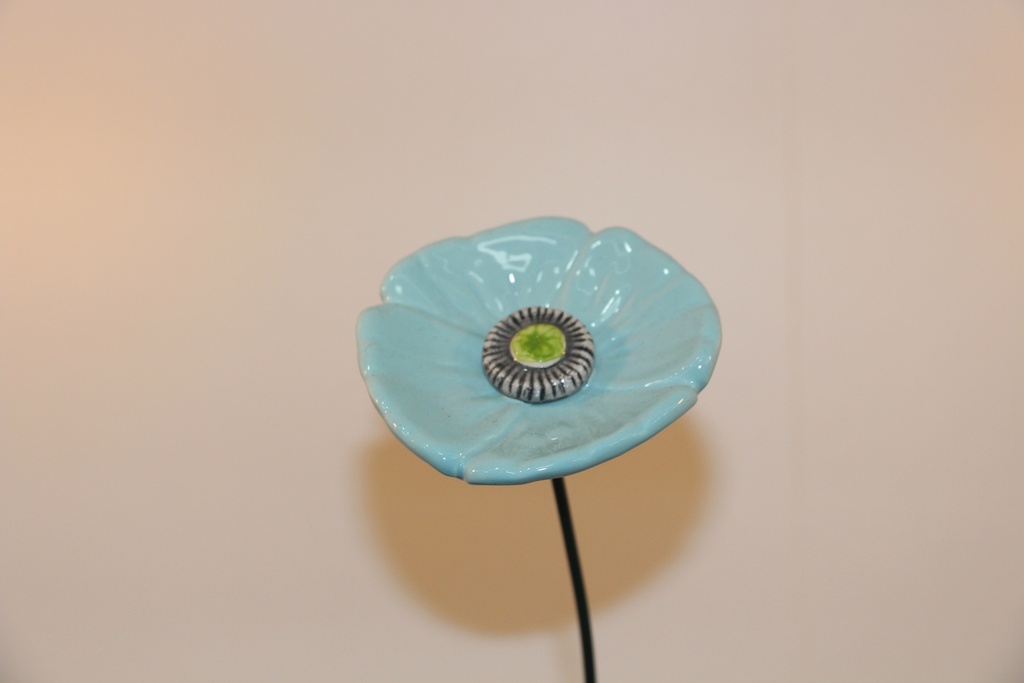 Flor decorativa em cerâmica azul-turquesa com haste metálica