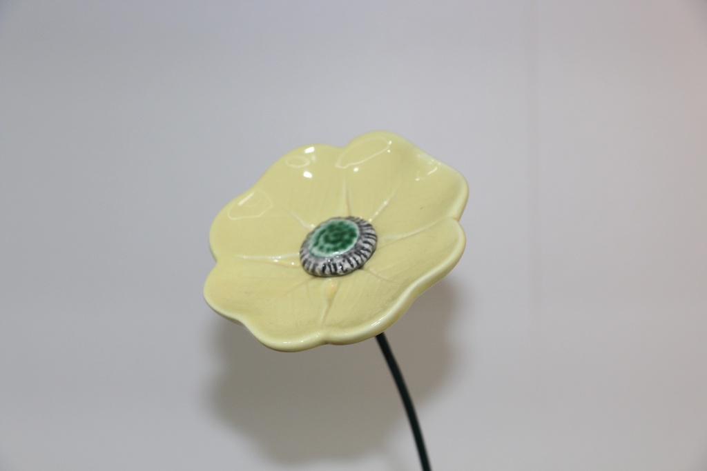 Flor decorativa em cerâmica amarela com haste metálica