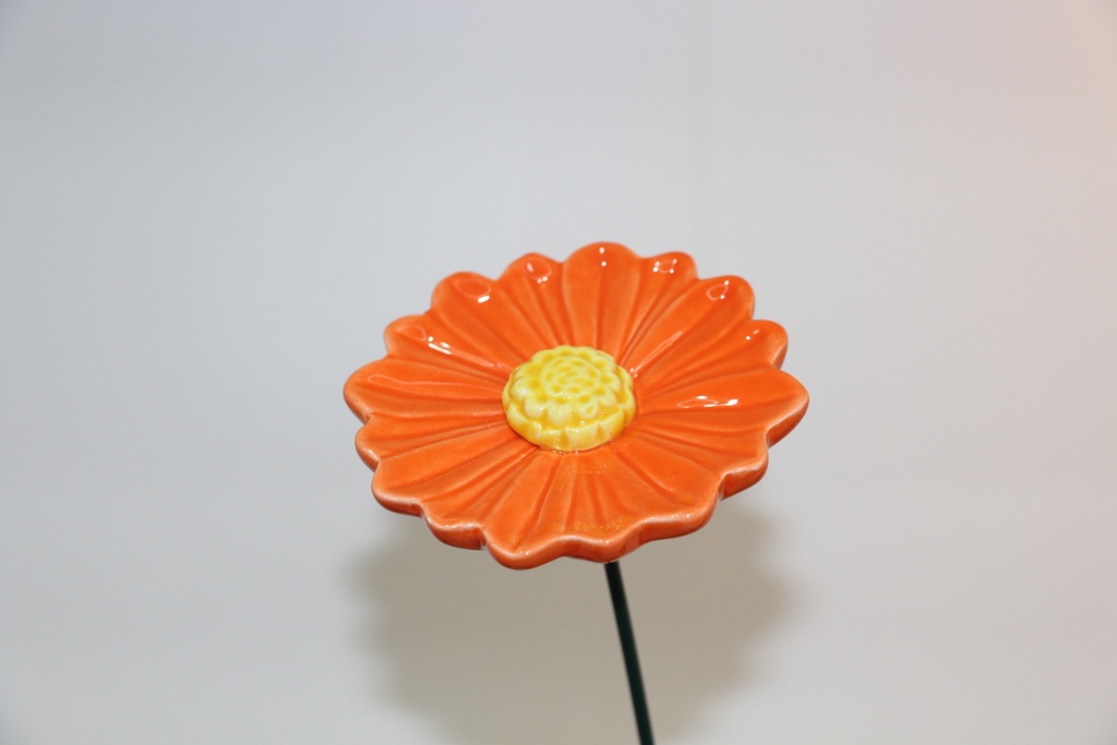 Flor decorativa em cerâmica laranja com haste metálica