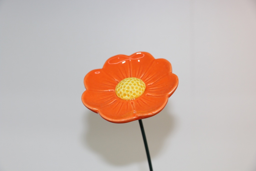 Flor decorativa em cerâmica laranja com centro alveolado e haste metálica