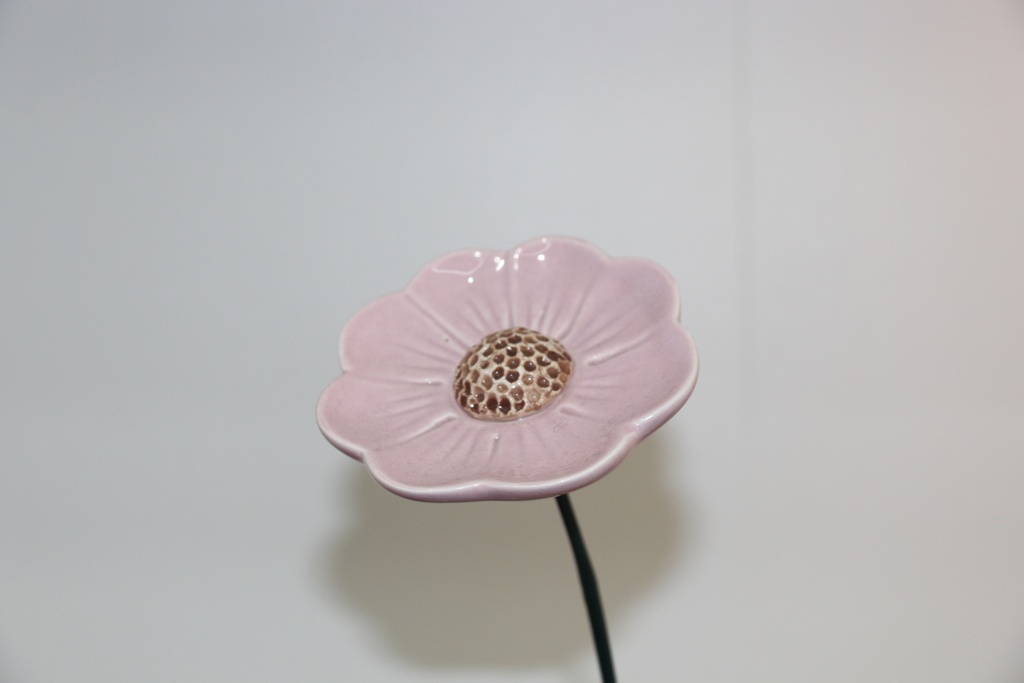 Flor decorativa em cerâmica rosa com centro pontilhado e haste metálica